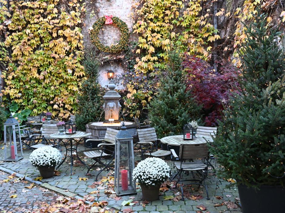 Sie sehen einen winterlich geschmückten Garten im Advent mit Sitzmöglichkeiten.