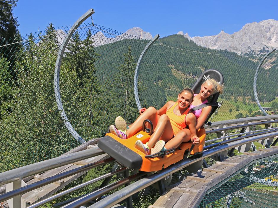 Tenns bei einer rasanten Fahrt mit dem Alpine Coaster am Rittisberg in Schladming-Dachstein. JUFA Hotels bieten erholsamen Familienurlaub und einen unvergesslichen Winter- und Wanderurlaub.