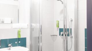 Sie sehen ein Bild von einem Badezimmer mit Dusche und WC in den Einzel- und Doppelzimmern im JUFA Hotel Garni Stubenberg in der Oststeiermark.