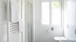 Sie sehen ein Bild vom Badezimmer in den Family & Friends-Zimmern im JUFA Hotel Garni Stubenberg in der Oststeiermark mit Dusche, Heizkörper und WC