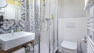 Sie sehen ein Badezimmer im Doppelzimmer im JUFA Hotel Salzburg City. Der Ort für erholsamen Familienurlaub und einen unvergesslichen Winter- und Wanderurlaub.