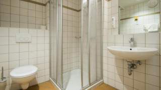 Badezimmer mit Dusche im JUFA Hotel Jülich. Der Ort für kinderfreundlichen und erlebnisreichen Urlaub für die ganze Familie.
