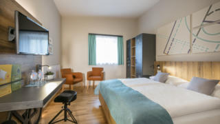 Sie sehen ein Doppelzimmer im JUFA Hotel Erlaufsee. Der Ort für erholsamen Familienurlaub und einen unvergesslichen Winter- und Wanderurlaub.
