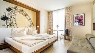Doppelbett in einem Doppelzimmer im JUFA Hotel Wien City, der Ort für einen erlebnisreichen Städtetrip für die ganze Familie und der ideale Platz für Ihr Seminar.