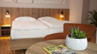 Sie sehen ein Bett im Familienzimmer FF3 im JUFA Hotel Mariazell – Erlaufsee Sport-Resort. Der Ort für erfolgreiches Training in ungezwungener Atmosphäre für Vereine und Teams.