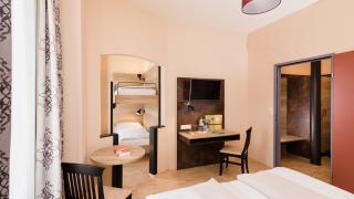 Sie sehen vier Betten in einem Appartement xlarge im JUFA Hotel Fürstenfeld - Sport-Resort. Der Ort für erfolgreiches Training in ungezwungener Atmosphäre für Vereine und Teams.
