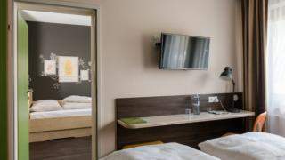 Sie sehen Betten im Appartement large im JUFA Hotel Graz-Süd. Der Ort für erlebnisreichen Städtetrip für die ganze Familie und der ideale Platz für Ihr Seminar.