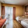 Betten im Doppelzimmer im JUFA Hotel Jülich mit Sofa. Der Ort für kinderfreundlichen und erlebnisreichen Urlaub für die ganze Familie.