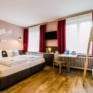 Sie sehen Betten im Familienzimmer Typ Family and Friends 4 im JUFA Hotel Königswinter/Bonn mit TV. JUFA Hotels bietet erlebnisreichen Städtetrip für die ganze Familie und den idealen Platz für Ihr Seminar.