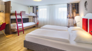 Sie sehen vier Betten im FF4 Zimmer im JUFA Hotel Salzburg City. Der Ort für erholsamen Familienurlaub und einen unvergesslichen Winter- und Wanderurlaub.