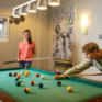 Sie sehen zwei Jugendliche beim Billiard Spiel im JUFA Kempten. Der Ort für kinderfreundlichen und erlebnisreichen Urlaub für die ganze Familie.