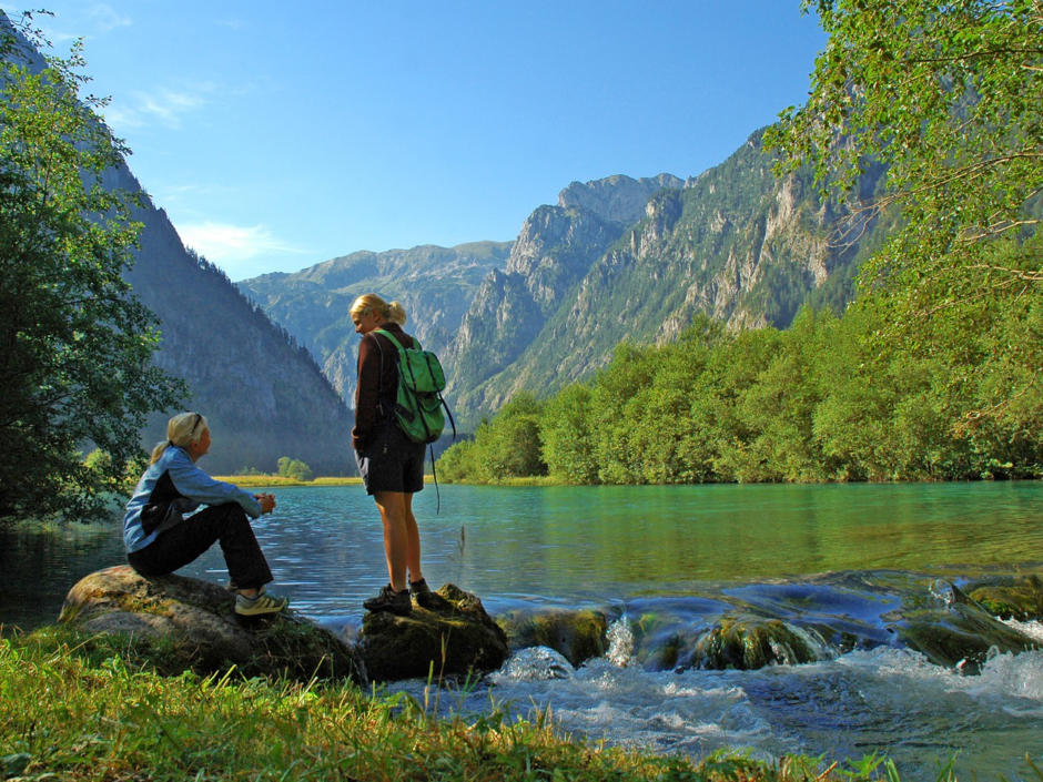 Zwei Frauen machen eine Wanderpause am Ufer des Brunnsees im Natur- und Geopark Steirische Eisenwurzen. JUFA Hotels bietet Ihnen den Ort für erlebnisreichen Natururlaub für die ganze Familie.