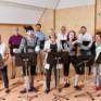 Sie sehen einen Chor in der Musikakademie Knappenberg mit Pantomimen. JUFA Hotels bietet den idealen Platz zum Musizieren und Singen in der Gemeinschaft in abwechslungsreichen Regionen.