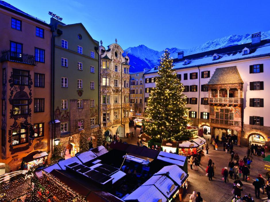 Sie sehen den Christkindlmarkt in Innsbruck bei Dämmerung. JUFA Hotels bietet erholsamen Familienurlaub und einen unvergesslichen Winter- und Wanderurlaub.
