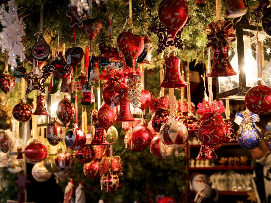 Sie sehen Christbaumkugeln, Glocken und Behang auf einem Weihnachtsmarkt.