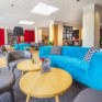 Sie sehen eine Couch in der Lounge im JUFA Hotel Salzburg City. Der Ort für erholsamen Familienurlaub und einen unvergesslichen Winter- und Wanderurlaub.