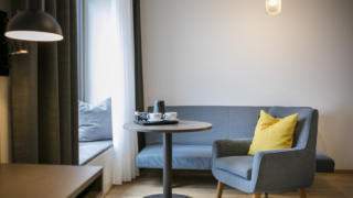 Sie sehen den Sitzbereich einer Suite im JUFA Hotel Hamburg HafenCity. Der Ort für kinderfreundlichen und erlebnisreichen Urlaub für die ganze Familie.