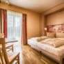 Doppelbett im Doppelzimmer im JUFA Hotel Jülich mit Terrasse. Der Ort für kinderfreundlichen und erlebnisreichen Urlaub für die ganze Familie.