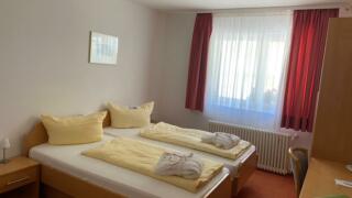 Sie sehen ein Doppelbett im Doppelzimmer im JUFA Hotel Schwarzwald. 