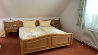 Sie sehen ein Doppelbett im Familienzimmer im JUFA Hotel Schwarzwald.