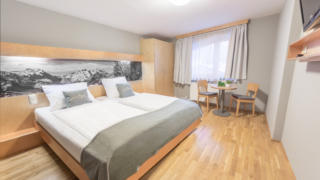 Sie sehen ein Doppelbett in einem Doppelzimmer vom JUFA Hotel Montafon. Der Ort für erholsamen Familienurlaub und einen unvergesslichen Winter- und Wanderurlaub.