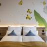 Sie sehen ein Doppelzimmer für zwei Personen im JUFA Hotel Bad Radkersburg mit komfortablem Boxpringbett, modernem Möbiliar und kreativer Wanddeko.