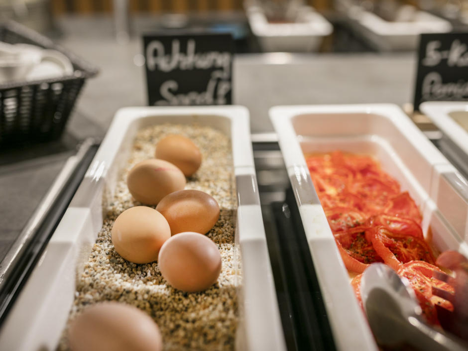 Sie sehen Eier und Tomatenscheiben am Frühstücksbuffet im JUFA Hotel Weiz. Der Ort für erholsamen Familienurlaub und einen unvergesslichen Winter- und Wanderurlaub.