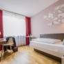 Sie sehen ein Einzelbett in einem Einzelzimmer im JUFA Hotel Königswinter/Bonn mit TV. JUFA Hotels bietet erlebnisreichen Städtetrip für die ganze Familie und den idealen Platz für Ihr Seminar.