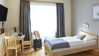 Sie sehen ein Einzelbett in einem Doppelzimmer im JUFA Hotel Pöllau - Bio-Landerlebnis. Der Ort für erholsamen Familienurlaub und einen unvergesslichen Winter- und Wanderurlaub.