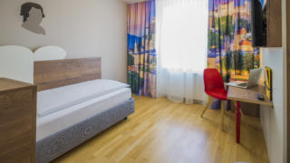 Sie sehen ein Einzelbett im Einzelzimmer im JUFA Hotel Salzburg City. Der Ort für erholsamen Familienurlaub und einen unvergesslichen Winter- und Wanderurlaub.