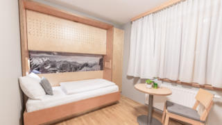 Sie sehen ein Einzelzimmer im JUFA Hotel Montafon. Der Ort für erholsamen Familienurlaub und einen unvergesslichen Winter- und Wanderurlaub.