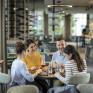 Sie sehen eine vierköpfige Familie beim gemütlichen Mittag- und Abendessen im Café & Restaurant Wandelhalle im JUFA Hotel Bad Radkersburg