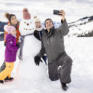 Sie sehen eine Familie, die ein Selfie mit dem gebauten Schneemann macht. Das JUFA Hotel Laterns - Klangholzhus ist der ideale Ort für einen abwechslungsreichen Familien-Winterurlaub und unvergessliche Tage im Schnee.