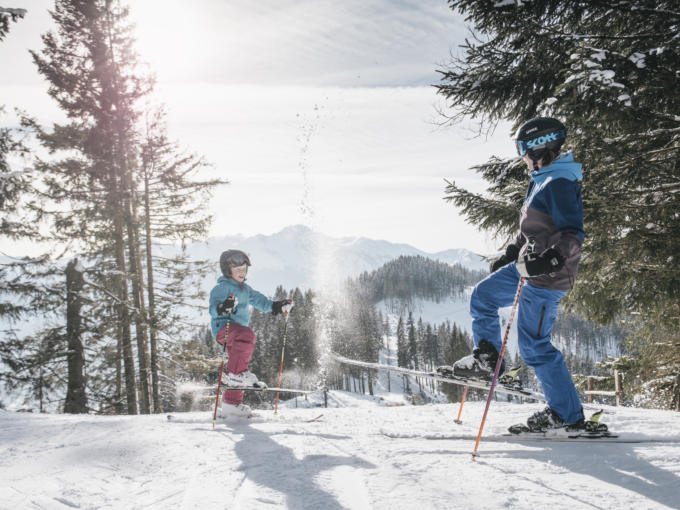 Sie sehen eine Familie im Skigebiet Kaiserau, die Spaß hat im Schnee. JUFA Hotels bietet erholsamen Familienurlaub und einen unvergesslichen Winterurlaub.