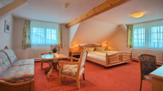 Sie sehen Betten im Dreibettzimmer im JUFA Hotel Schwarzwald. Der Ort für erholsamen Familienurlaub und einen unvergesslichen Winterurlaub.
