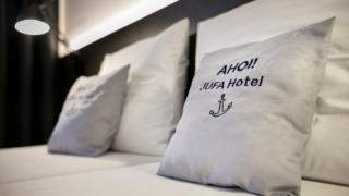 Sie sehen Kissen auf einem Doppelbett. JUFA Hotels bietet kinderfreundlichen und erlebnisreichen Urlaub für die ganze Familie.