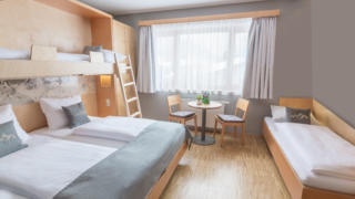 Sie sehen ein Familienzimmer für 4 Personen im JUFA Hotel Montafon. Der Ort für erholsamen Familienurlaub und einen unvergesslichen Winter- und Wanderurlaub.