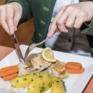 Sie sehen ein Fischgericht im Restaurant im JUFA Hotel Grundlsee*** mit Gemüse. JUFA Hotels bietet erholsamen Familienurlaub und einen unvergesslichen Winterurlaub.