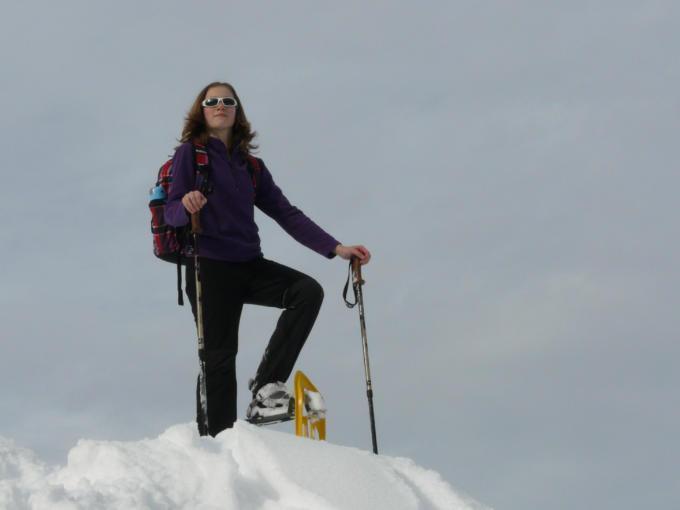 Sie sehen eine Schneeschuhwandererin auf einem Gipfel im Murtal stehen. JUFA Hotels bietet erholsamen Familienurlaub und einen unvergesslichen Winterurlaub.