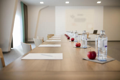 Sie sehen Getränke und Äpfel auf den Tischen im Seminarraum Bürgeralpe im JUFA Hotel Erlaufsee. Der Ort für erfolgreiche und kreative Seminare in abwechslungsreichen Regionen.