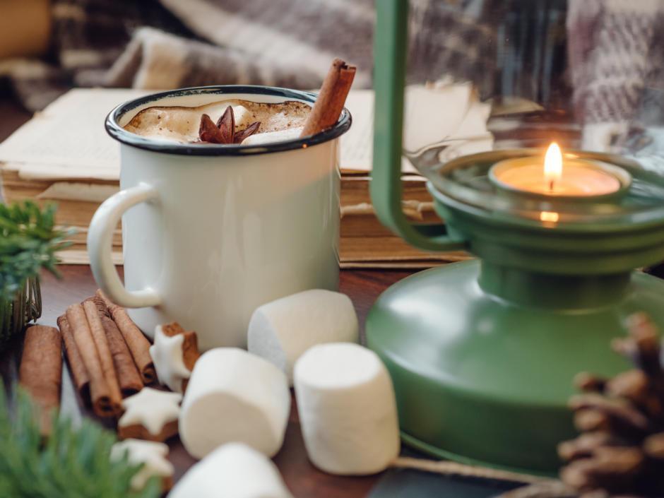 Sie sehen eine heiße Schokolade mit Zimt und Marshmallows auf einem Weihnachtsmarkt. JUFA Hotels bietet erholsamen Familienurlaub und einen unvergesslichen Winterurlaub.