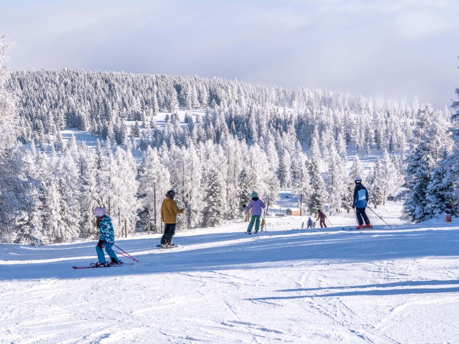 Sie sehen mehrere Personen beim Skifahren auf der Hochrindl in den Nockbergen.
