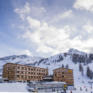 Sie sehen eine Außenansicht vom JUFA Hotel Malbun – Alpin-Resort*** mit Piste im Winter. JUFA Hotels bietet erholsamen Familienurlaub und einen unvergesslichen Winterurlaub.