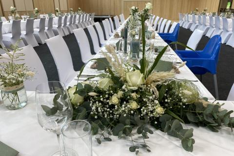 Sie sehen den Blumenschmuck auf einer Tafel in der All in One Eventhalle im JUFA Hotel Lipizzanerheimat in Maria Lankowitz.