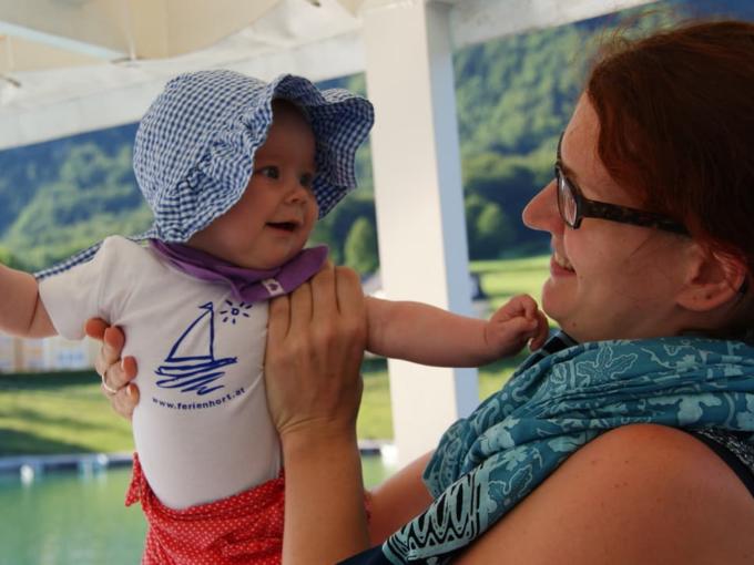 Judith List mit Baby am See. JUFA Hotels bieten erholsamen Familienurlaub und einen unvergesslichen Winter- und Wanderurlaub.