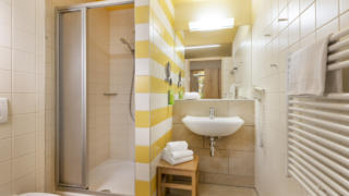 Sie sehen ein Badezimmer mit WC im JUFA Hotel Bleiburg / Pliberk. Der Ort für erholsamen Familienurlaub und einen unvergesslichen Winter- und Wanderurlaub.
