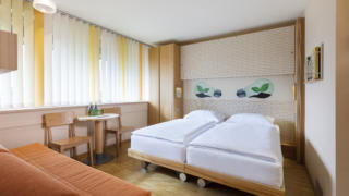 Sie sehen ein Doppelzimmer im JUFA Hotel Bleiburg / Pliberk. Der Ort für erholsamen Familienurlaub und einen unvergesslichen Winter- und Wanderurlaub.