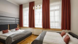 Sie sehen ein Doppelbett und ein Sofa-Doppelbett im Family & Friends plus für 4 Personen im JUFA Hotel Bregenz am Bodensee. Der Ort für einen unvergesslichen Wander-, Rad- und Kultururlaub für Familien, Freunde und Paare.