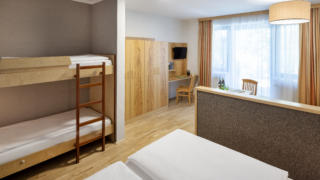 Sie sehen ein Zimmer aus der Kategorie FF5 im JUFA Hotel im Weitental / Bruck a.d. Mur. JUFA Hotels bietet erholsamen Familienurlaub und einen unvergesslichen Winter- und Wanderurlaub.