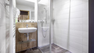 Sie sehen ein Badezimmer aus der Kategorie Appartement 5 im JUFA Hotel Malbun. Der Ort für erholsamen Familienurlaub und einen unvergesslichen Winter- und Wanderurlaub.